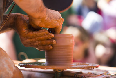 Midsection of potter making bowl in market