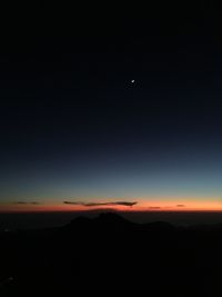 Silhouette landscape against sky at night