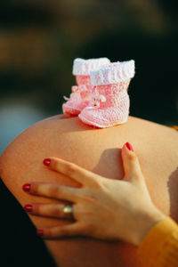 Close-up of pregnant woman with baby booties on abdomen