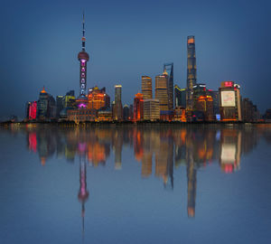 Reflection of buildings in city at waterfront