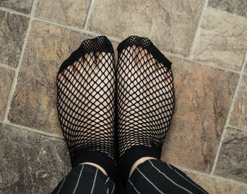 Low section of woman standing on tiled floor