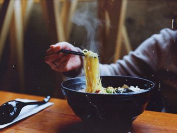 Cropped hand of person having noodles at home