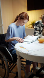 Rear view of a couple sitting on table