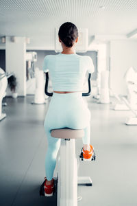 Rear view of woman with umbrella standing in corridor