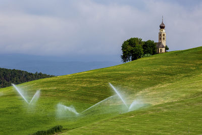 Scenic view of grassy field against sky