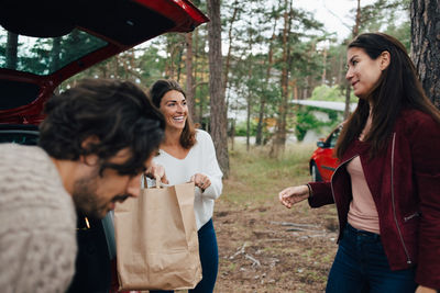 Young woman smiling while holding hands standing outdoors