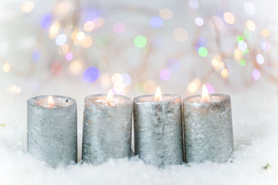 Close-up of illuminated candles on snow