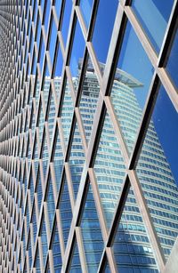 Low angle view of modern building against blue sky