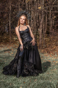 Portrait of young woman standing in forest