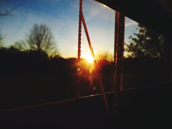 Close-up of silhouette trees against sunset sky