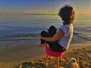 Rear view of women at beach against sky
