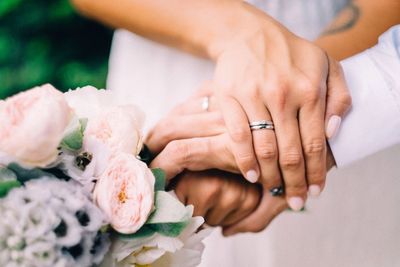 Cropped image of wedding couple holding hands