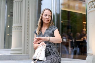 Street style cute woman blogger in gray dress and analog wrists. stylish woman