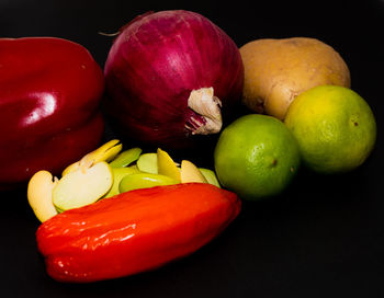 Close-up of fruits and vegetables on table against black background
