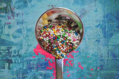 Close-up of colorful sprinkles in spoon over table