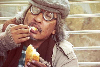 Man looking away while eating food