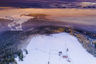 Scenic view of snow covered landscape against sky during sunset