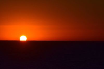 Scenic view of sea against orange sky