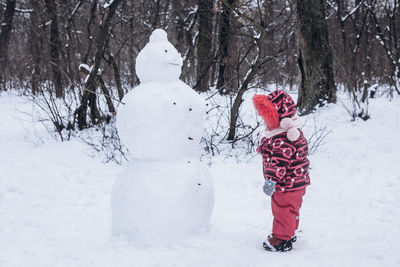 Full length of child standing on snow covered land