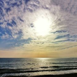 Scenic view of sea against cloudy sky at sunset