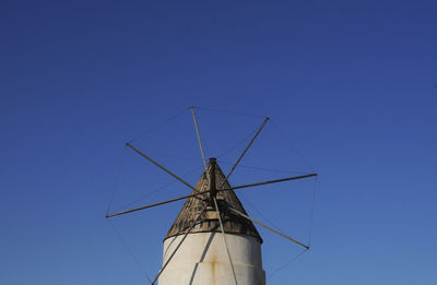 Low angle view of windmill against blue sky in cabo de gata nature park, spain