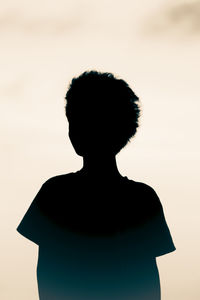 Rear view of silhouette woman standing against sky