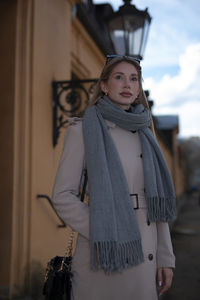 Portrait of woman standing against wall