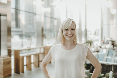 Portrait of happy woman standing in cafe