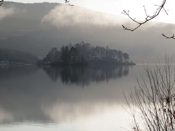 Scenic view of lake by trees against sky