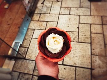 High angle view of person holding ice cream on floor