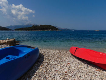 Boat moored on sea against blue sky