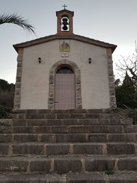 Low angle view of cross on building against sky