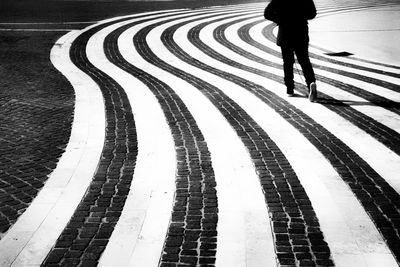 Low section of person standing on footpath in city