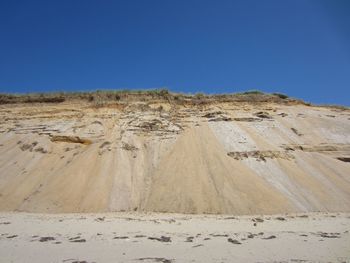 Scenic view of desert against clear blue sky