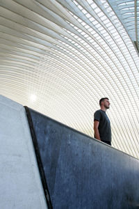 Low angle view of man standing on escalator