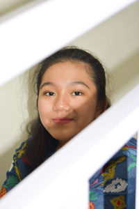 Portrait of a young girl wearing blue outfit and jeans sitting at the stairs posing for the camera 