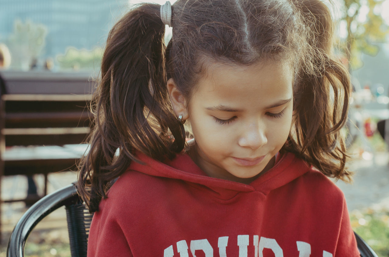 child, childhood, girls, females, women, real people, focus on foreground, headshot, lifestyles, portrait, leisure activity, looking, looking down, cute, people, hairstyle, day, innocence, hair, outdoors, contemplation