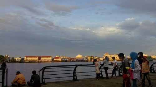 People in city against cloudy sky