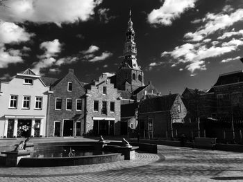 Buildings in city against cloudy sky