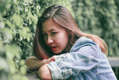 Portrait of beautiful young woman lying on land