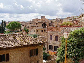 Buildings in town against cloudy sky