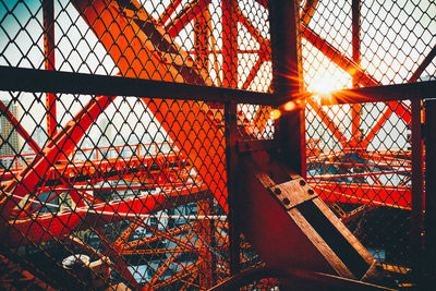 Chainlink fence against sky at sunset