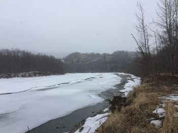 Scenic view of snow covered land against sky