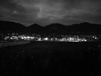 Illuminated city against sky at night