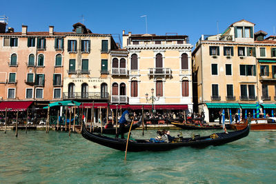 Boats in canal along buildings