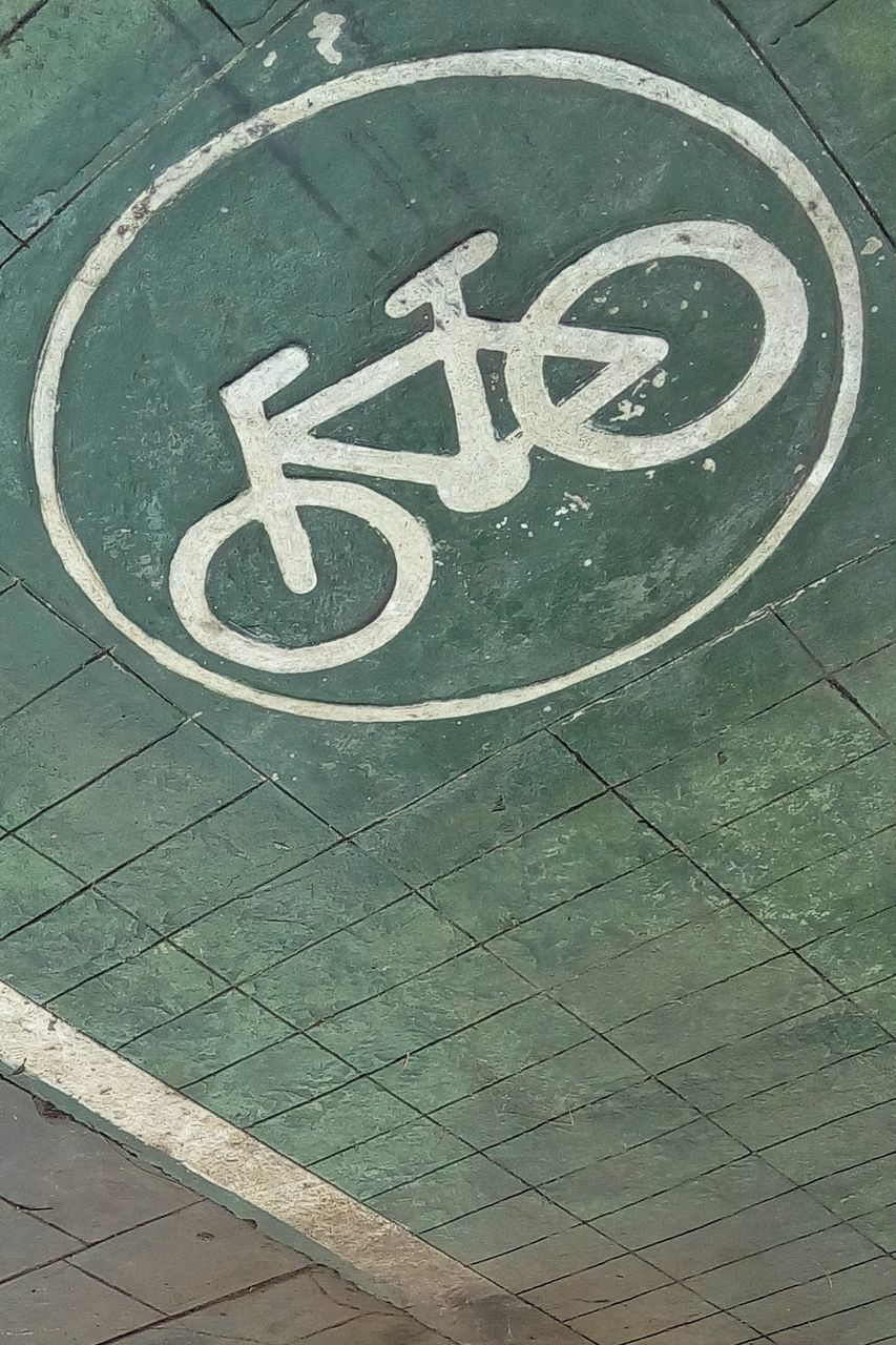 communication, sign, no people, high angle view, day, road sign, information, outdoors, close-up, information sign, footpath, architecture, text, bicycle, warning sign, flooring, built structure, bicycle lane, tile, direction