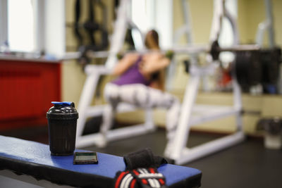 Woman exercising with water bottle in foreground