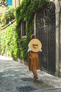 Rear view of woman standing against old building
