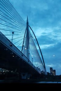Low angle view of suspension bridge against sky