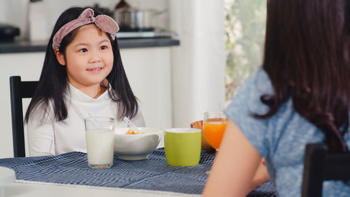 Portrait of cute girl sitting on table
